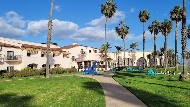 Landscaped green lawn with buildings, big chair, and large chess pieces Hilton Santa Barbara Beachfront Resort