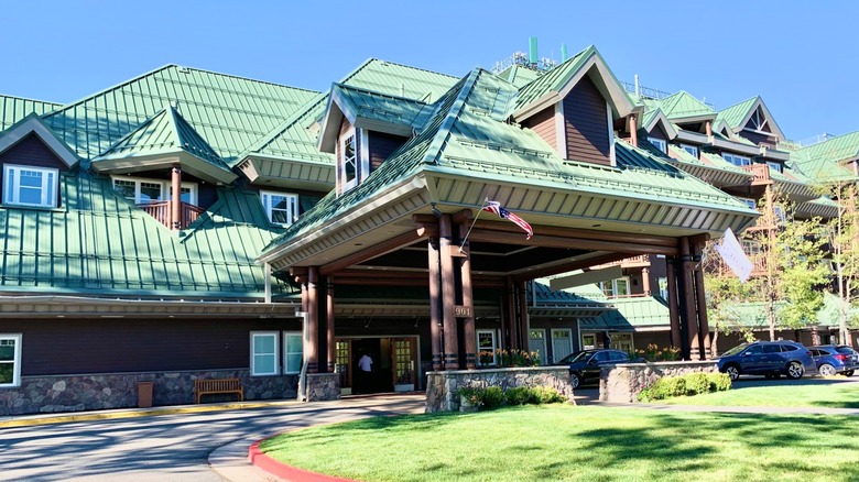 Hilton Vacation Club Lake Tahoe Resort South entrance against blue sky with flags and cars