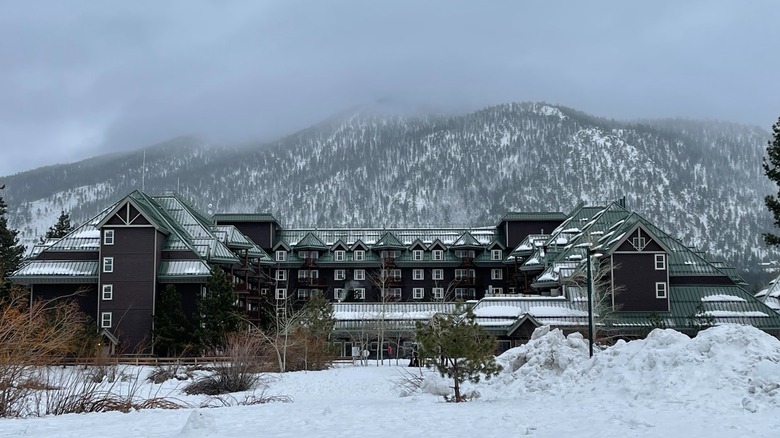 Outside of Hilton Vacation Club Lake Tahoe Resort South covered with snow and snowy mountain behind it