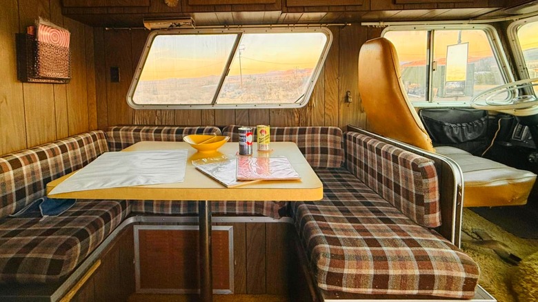 Interior of an Apollo Neptune Motorhome with wood paneling and brown plaid cushions