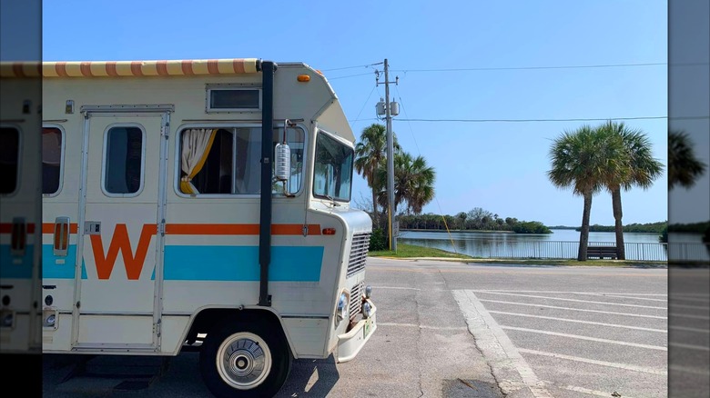 A 1972 Winnebago Brave parked on the waterfront with palm trees