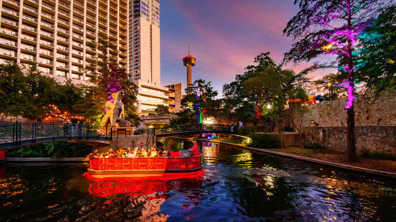 The San Antonio River Walk at sunset with sighseeing boat and hotel