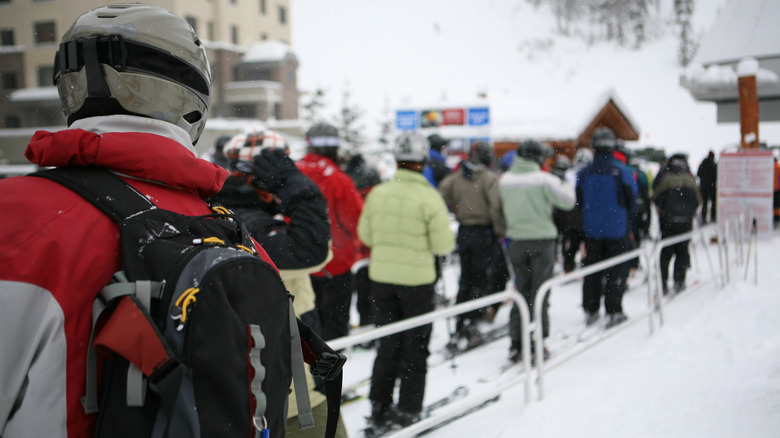 Skiers and snowboarders waiting in line for a chair lift
