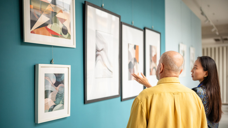 A man and woman discussing an artwork in a gallery