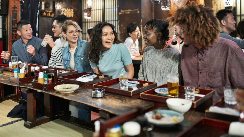 People dining at a traditional sushi bar counter in Tokyo, Japan