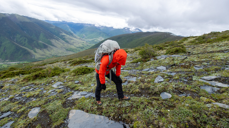 Hiker on mountain trail doubled over
