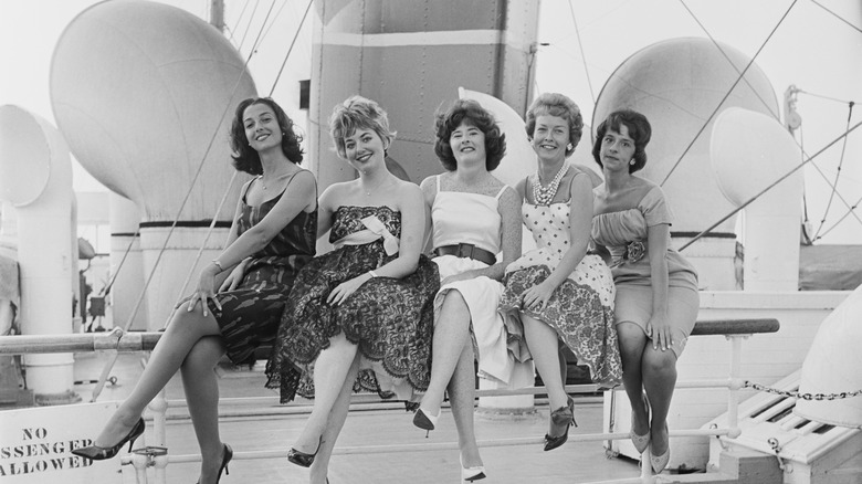 Women in dresses sitting on a cruise ship in the 1960s in a black-and-white photo
