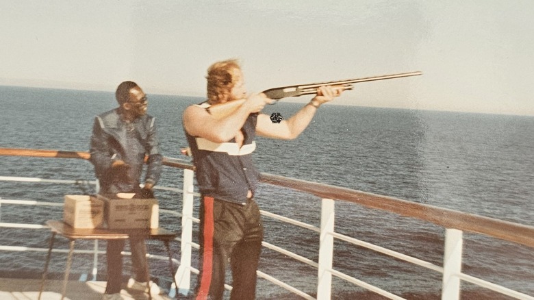 Man skeet shooting off a cruise ship in the 1980s