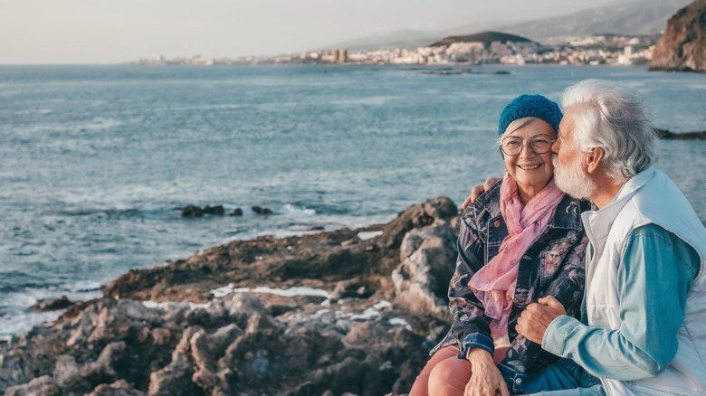 Older couple traveling and enjoying a sea view