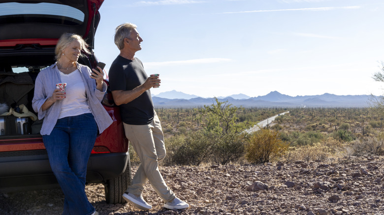 Older couple taking a roadside break overlooking a desert landscape