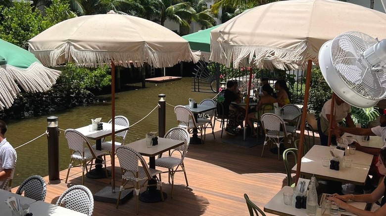 The intimate patio space at Café Bastille with people dining near the canal