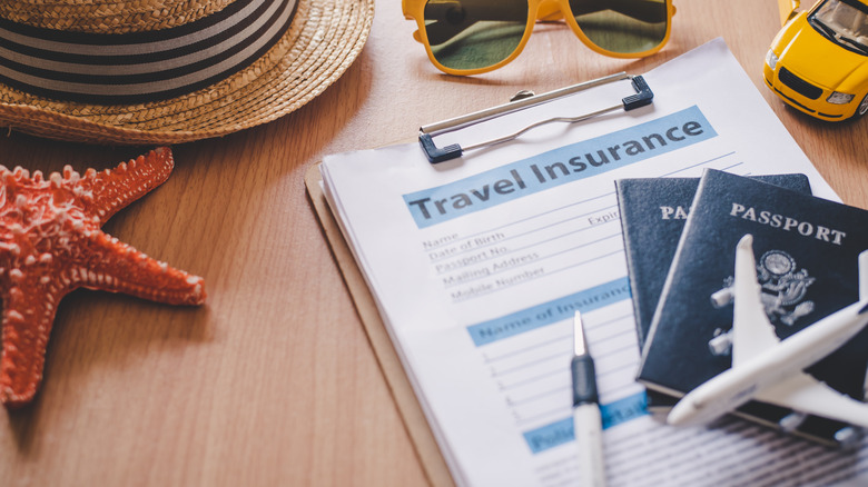 Travel insurance documents surrounded by travel-related objects