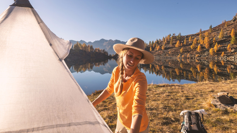 Woman pitching a tent in the backcountry