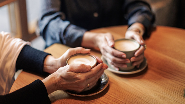 Hands holding cups of coffee