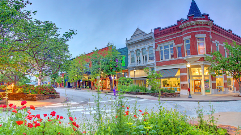 Red building surrounded by greenery and flower beds in downtown Fayetteville