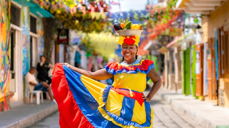 A woman wears a colorful traditional outfit on the streets of Cartagena, Colombia