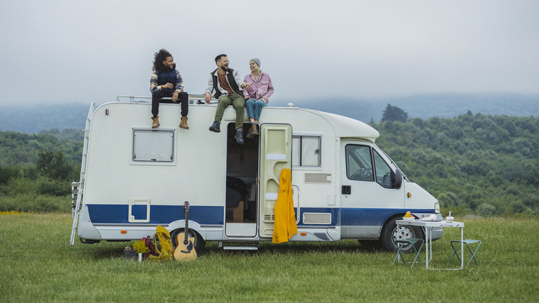Three friends sitting on top of an RV