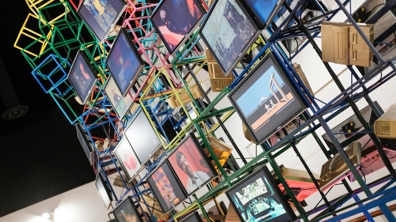Panel of screens with nostalgic video game equipment at the National Video Game Museum in Texas