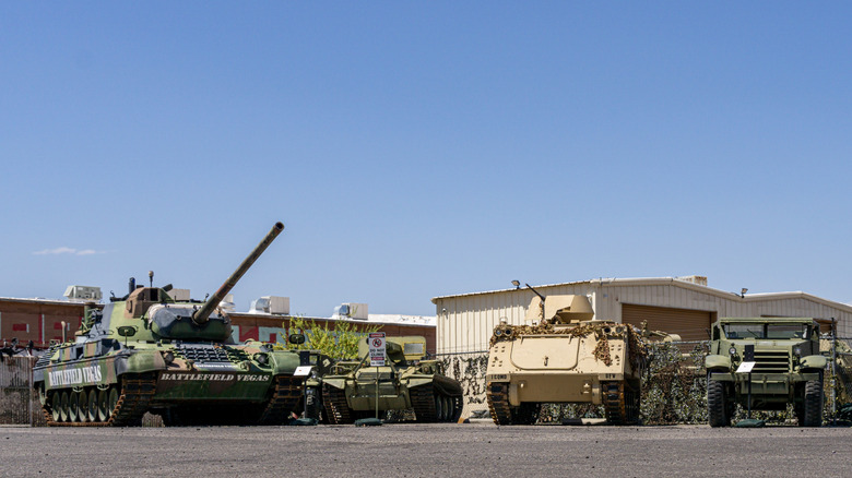 Tanks and armored vehicles form a line in front of a metal fence at Battlefield Vegas.
