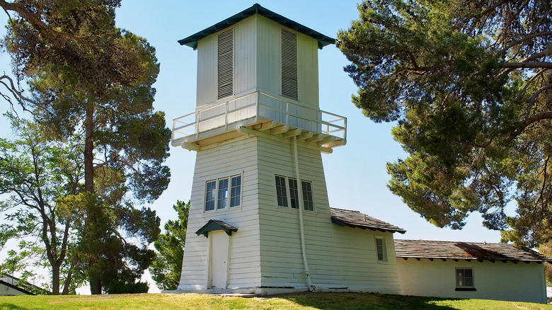 A white-washed water tower stands on a grassy hill at Tule Springs Ranch in Las Vegas.