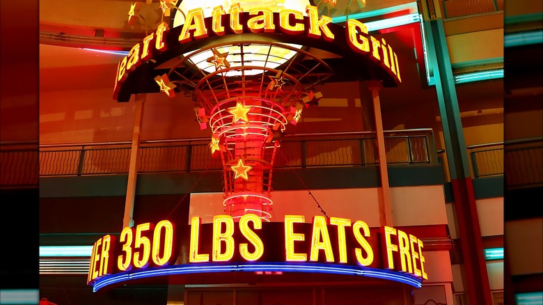 A lit-up sign at Heart Attack Grill reading "350 LBS EATS FREE"
