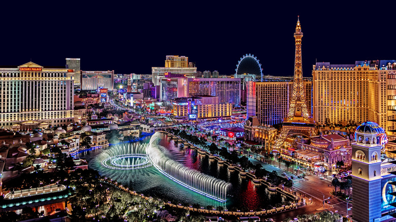 The multicolored Las Vegas skyline and Bellagio fountain on a dark, cloudless night.
