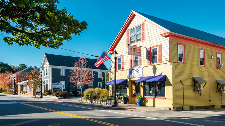 Downtown Bridgton, with a yellow-and-pink house next to a gray-and-white house along a street under a blue sky