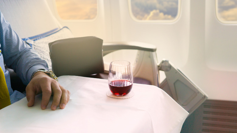 Airplane first class cabin table with a glass of red wine