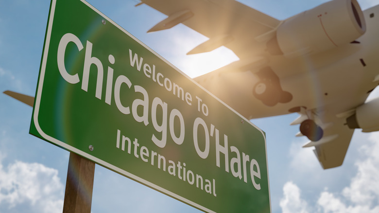 A plane descends over a sign for Chicago O'Hare International Airport
