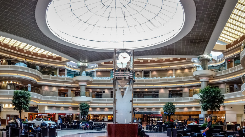 Main rotunda at Hartsfield-Jackson International Airport in Atlanta, with potted plants and people lounging in seating areas