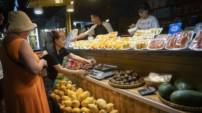 Tourists remain polite while buying fruit at a Vietnamese market