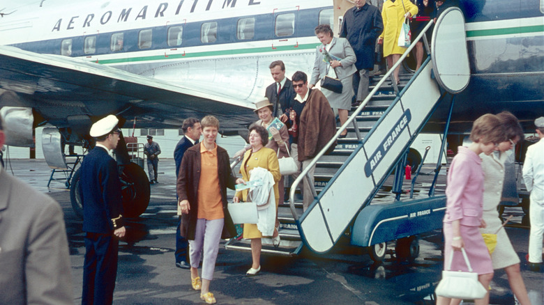 People getting of a flight in 1966