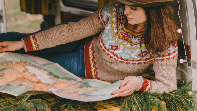 Person studying a paper map while traveling in an RV