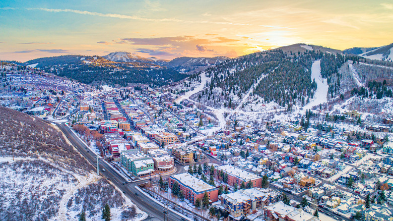 Snow-dusted rooftops gather closely together in front of ski runs in Park City, Utah.
