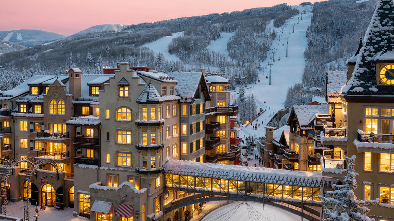 Alpine-style high rises stand in front of a ski run at sunset in Vail, Colorado.