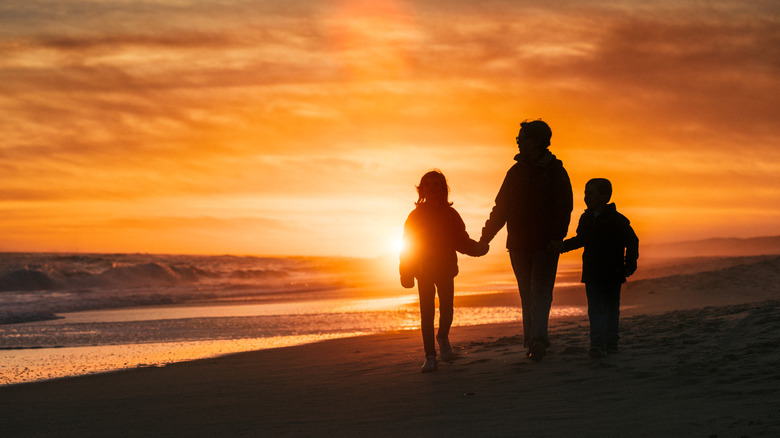 Family on a walk on a beach in the Hamptons at sunset