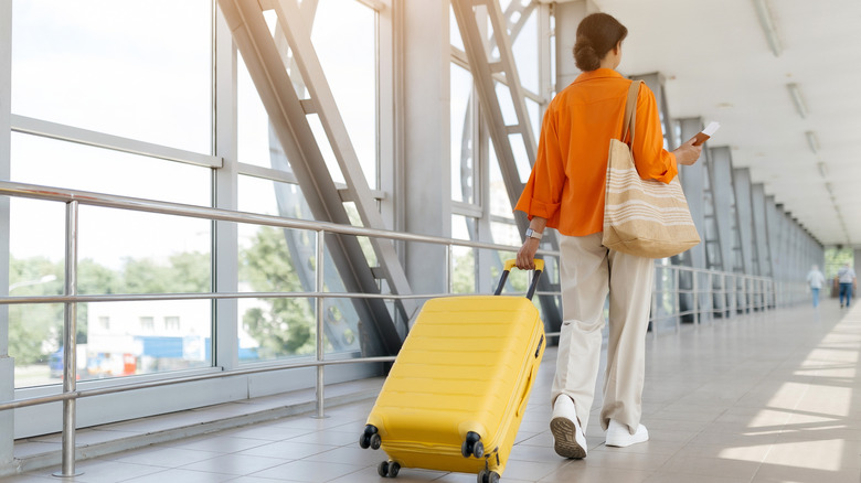 A woman walking with her suitcase