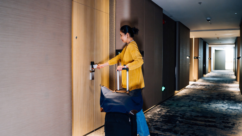 A person letting herself in a hotel room