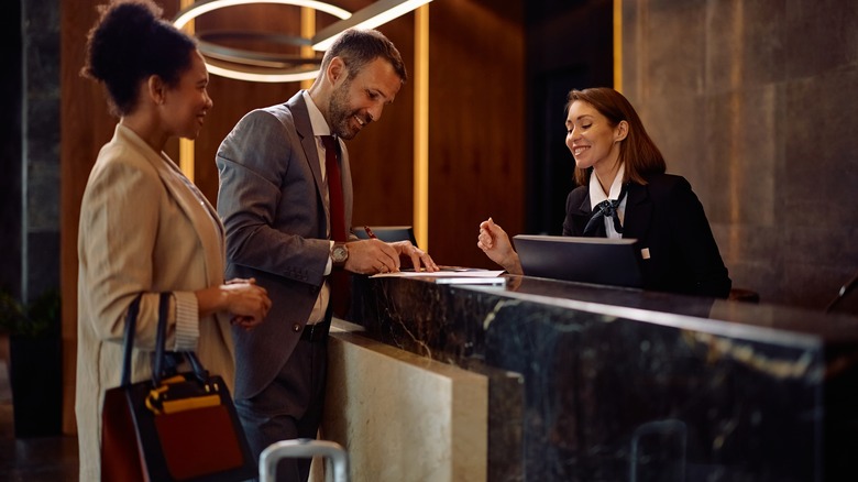 Travelers check into a hotel