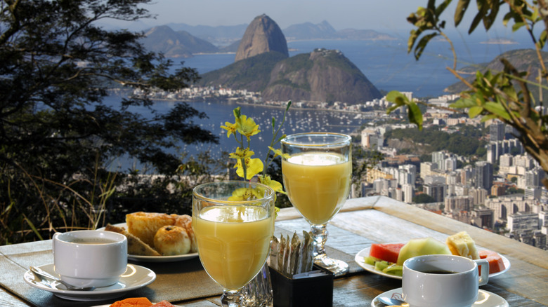 A breakfast table with food and coffee, overlooking  the coastline of Rio de Janeiro, Brazil