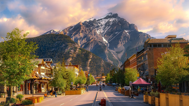 European-style houses and stores Banff road, framed by snow-capped mountain in distance