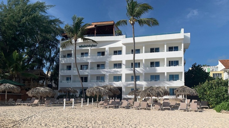 A white resort building, seen from the beach
