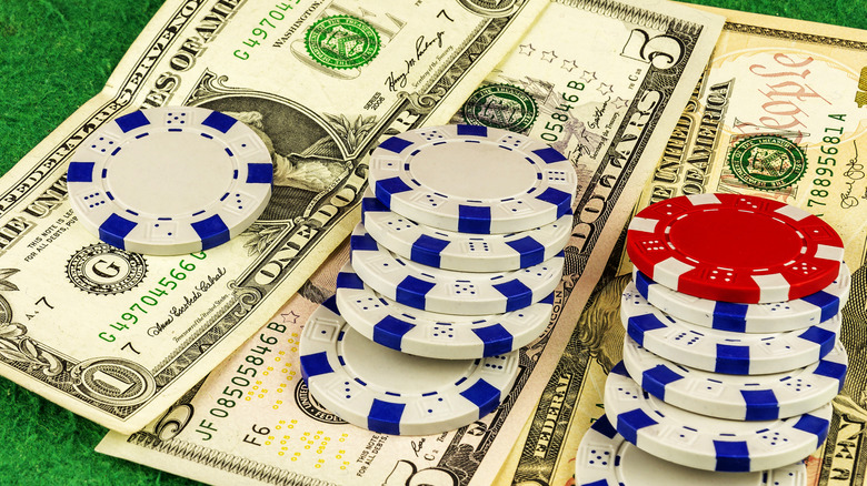 American monetary bank notes with various casino chips placed on top