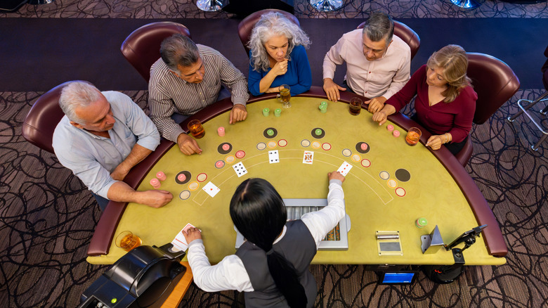 Aerial view of a group of older men and women sitting around a blackjack table in a casino