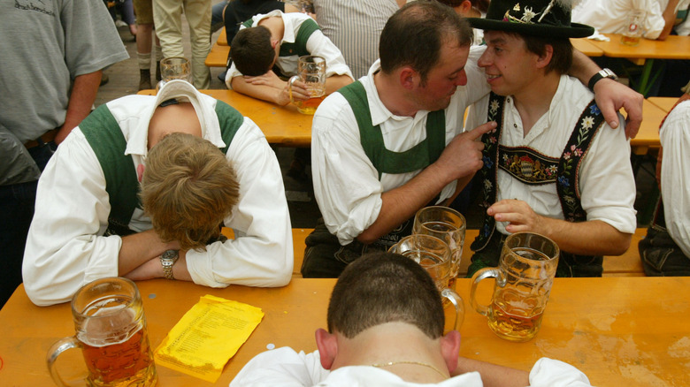 A group of young men drunk at Oktoberfest in traditional Bavarian outfits