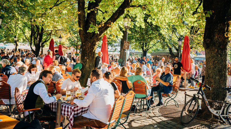 A group of people sitting at an outdoor beer garden in Munich, Germany