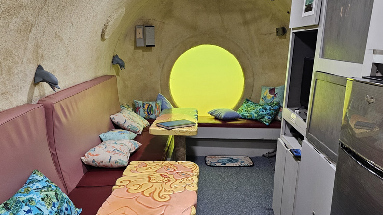 The interior of the Jules' Undersea Lodge in Key Largo, Florida with a port hole looking out to the murky lagoon