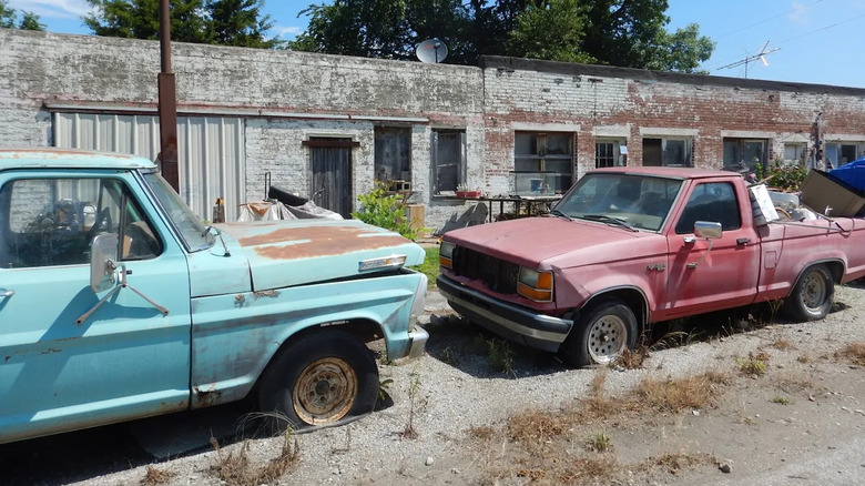 Two old cars in front of an abandoned building in Centralia, Oklahoma