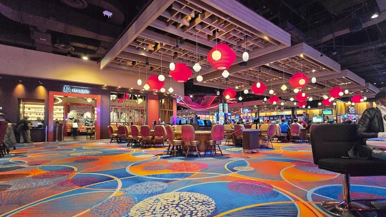 Interior of Rivers Casino, with colorful flooring, tables, and red pendant lights