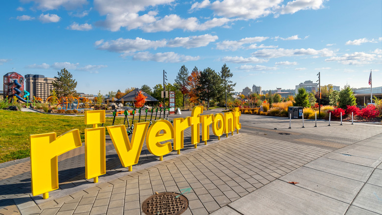A sign reading "riverfront" in Spokane's Riverfront Park on a sunny, fall day